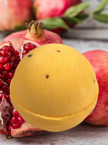 Yellow bath bomb with decorative pomegranate designs throughout.