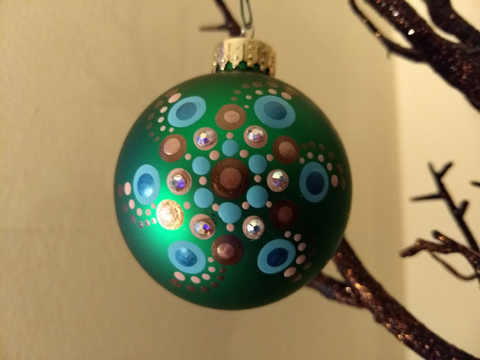 A painted swirl design on a green ornament. Embellished with crystal.