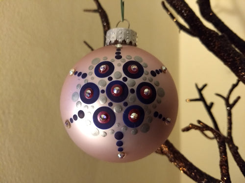 A pink and purple star design on a light pink ornament. Embellished with crystal