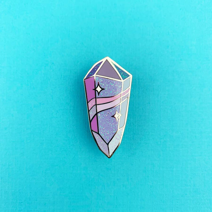 Enamel pin depicting a sparkling, stylized purple crystal.