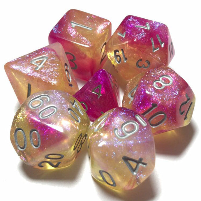 A tabletop dice set in sparkling magenta and gold with silver numbers.