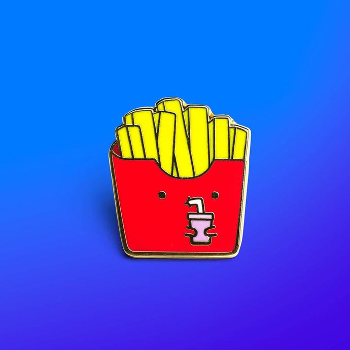 Enamel pin depicting a container of french fries with a cartoonish face, sipping from a drink with a straw.