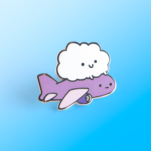 Enamel pin depicting a purple airplane with a disappointed face, behind ridden by a cloud with a smiley face.