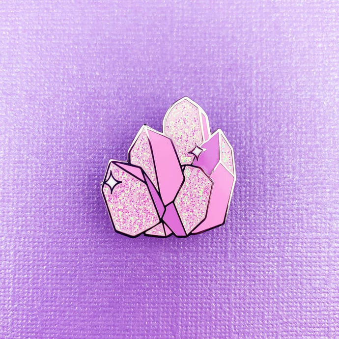 Enamel pin depicting several sparkling, stylized pink crystals.