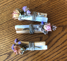 Load image into Gallery viewer, Bundles containing Palo Santo healing wood, a large selenite crystal, and flowers, bound by twine.
